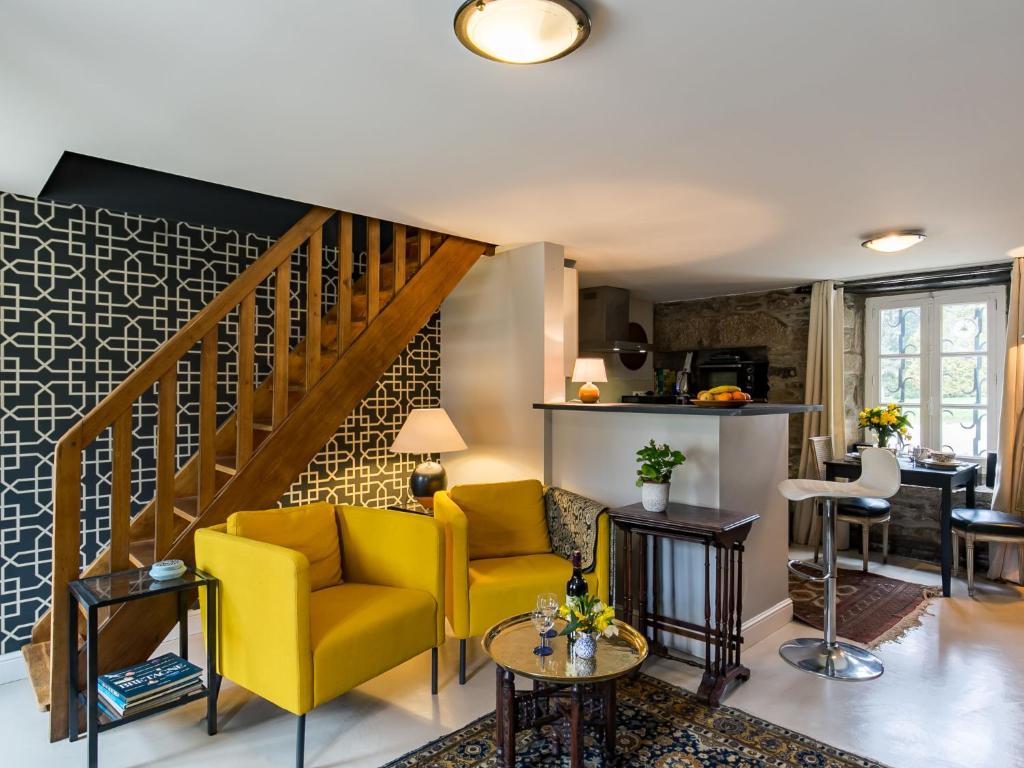 een woonkamer met een gele bank en een trap bij Apartment Le Manoir du Moros by Interhome in Concarneau