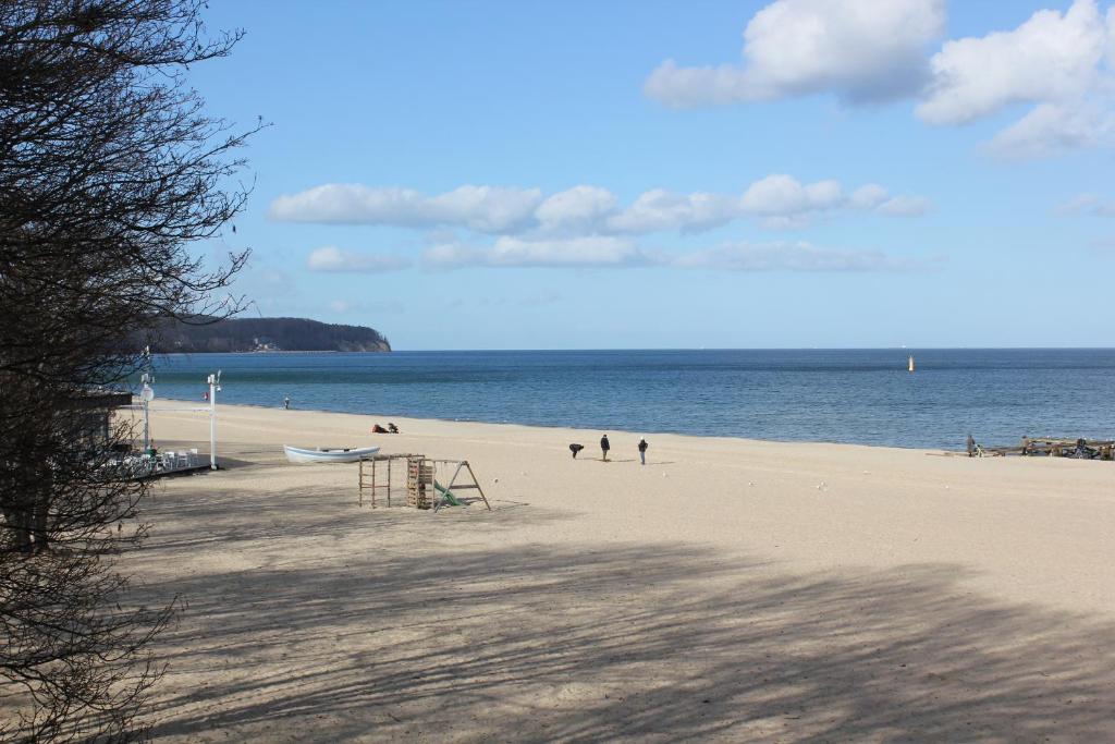 two people walking on a beach near the water at Park in Sopot