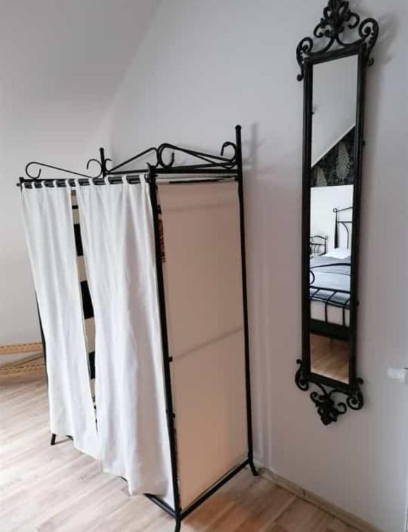 - un miroir et un rideau blanc dans la chambre dans l'établissement Ferienwohnung Mühlenbachhexe, à Lingen