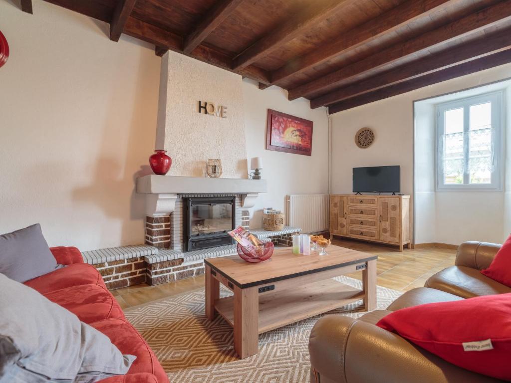 ein Wohnzimmer mit einem Sofa und einem Kamin in der Unterkunft Holiday Home Gîte La Truffière Saintongeaise by Interhome in Berneuil