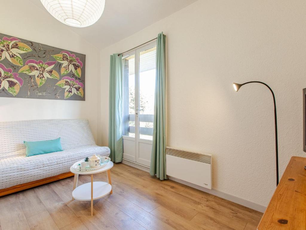 een woonkamer met een bank en een tafel bij Apartment Les Bourdaines by Interhome in Seignosse