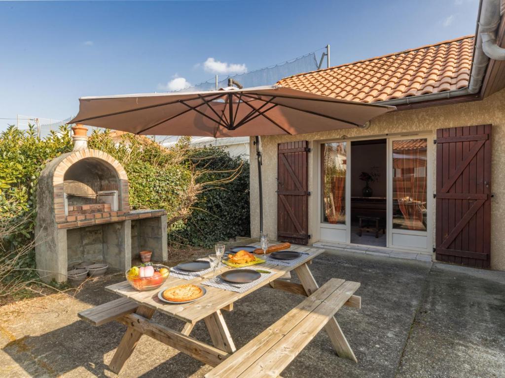 stół piknikowy z jedzeniem i piekarnikiem na świeżym powietrzu w obiekcie Holiday Home La Gare by Interhome w mieście Mimizan