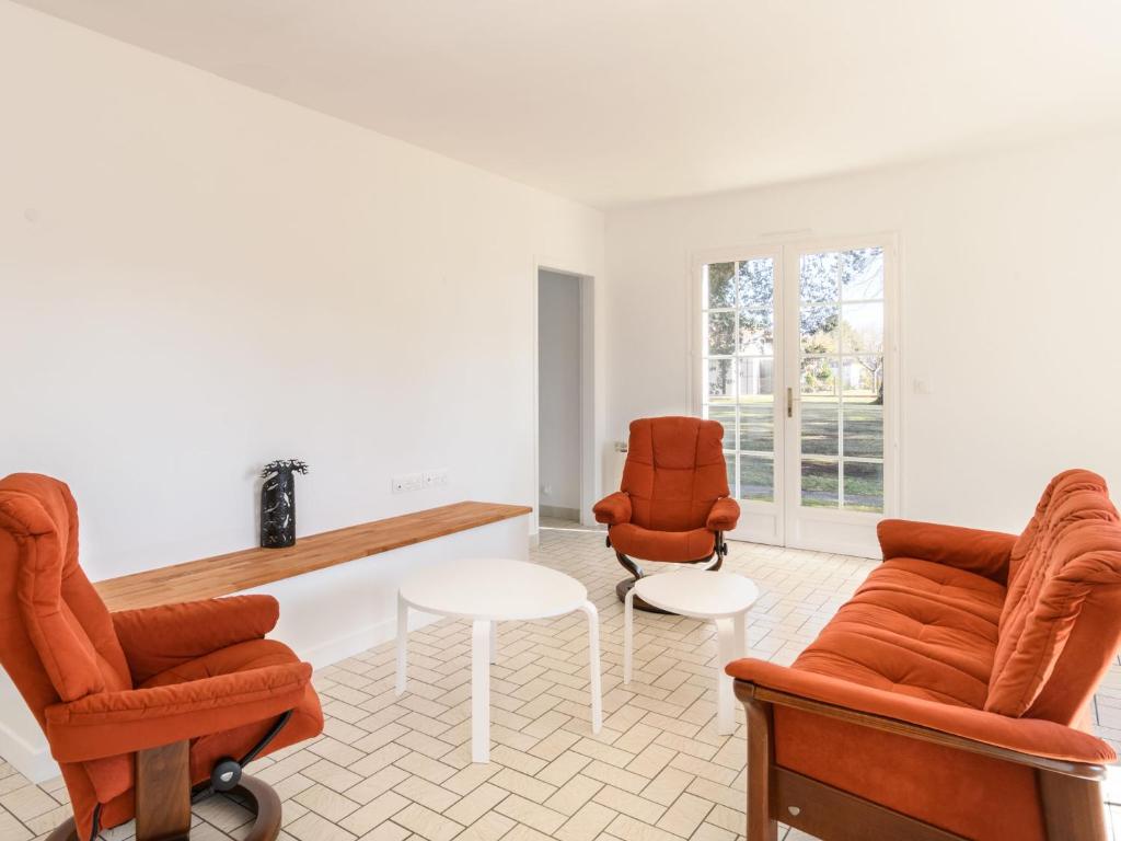 a living room with two chairs and a table at Holiday Home Les Chênes by Interhome in Lit-et-Mixe