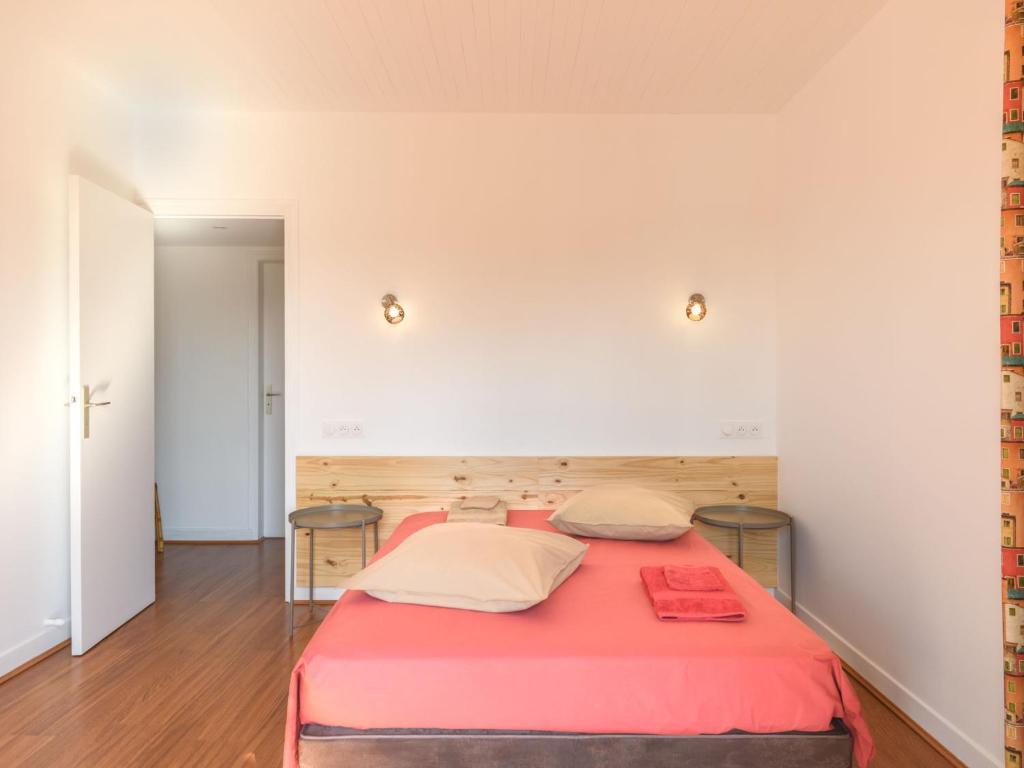 a bedroom with a red bed with two tables at Holiday Home Les Chênes by Interhome in Lit-et-Mixe