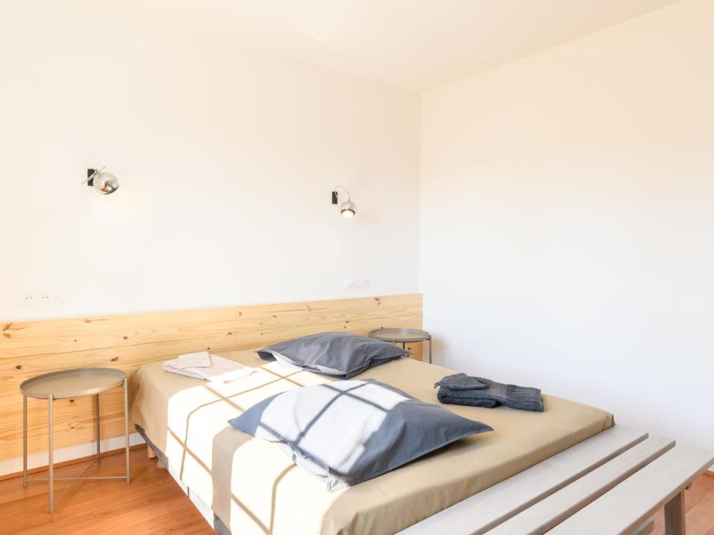 a bed in a room with white walls at Holiday Home Les Chênes by Interhome in Lit-et-Mixe
