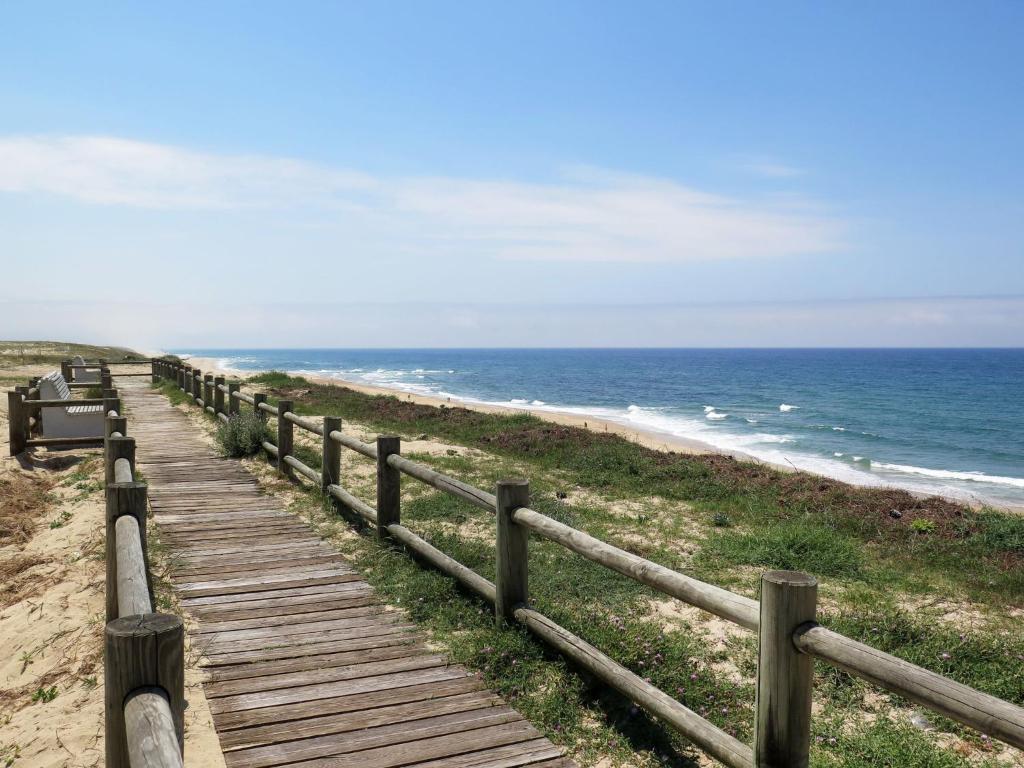 a wooden boardwalk leading to the ocean on a beach at Holiday Home Les Chênes by Interhome in Lit-et-Mixe