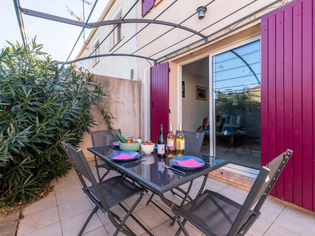 une table noire et des chaises sur une terrasse dans l'établissement Holiday Home L'Abrivado by Interhome, à Aigues-Mortes