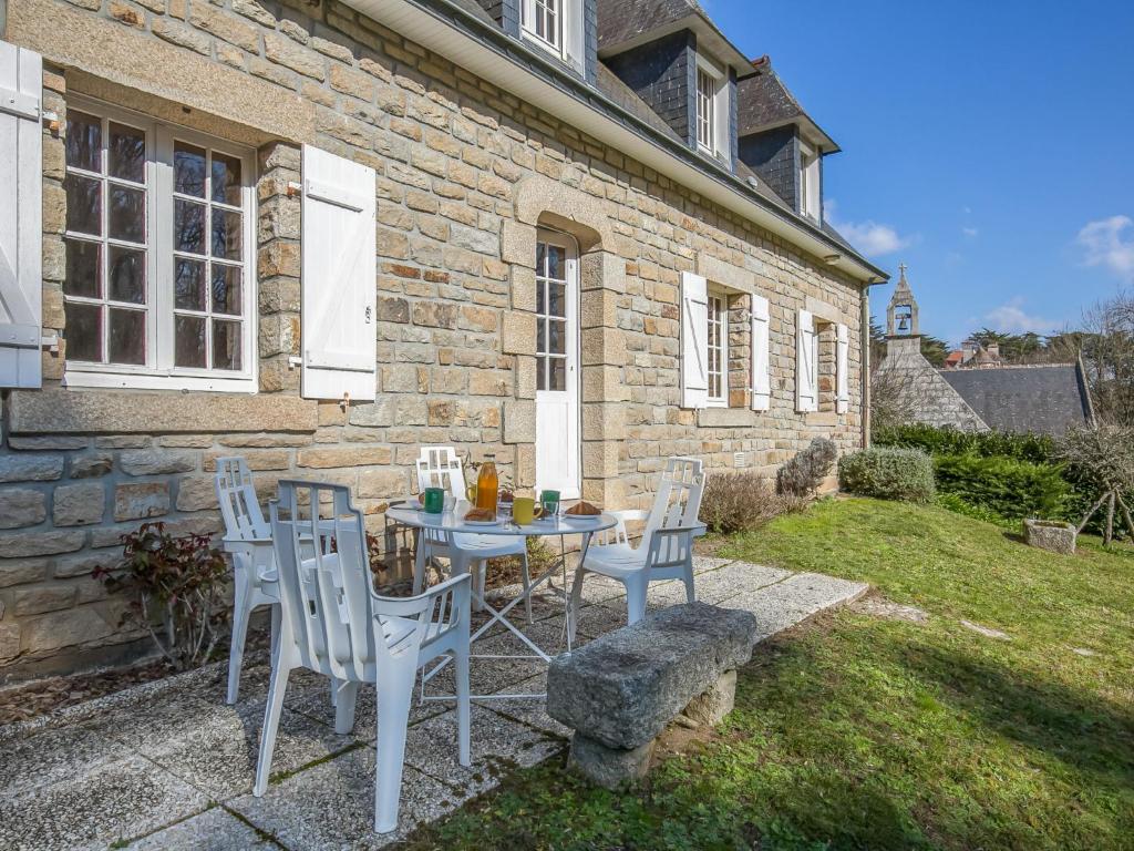 une table et des chaises devant une maison en briques dans l'établissement Holiday Home Saint Nicolas by Interhome, à Névez
