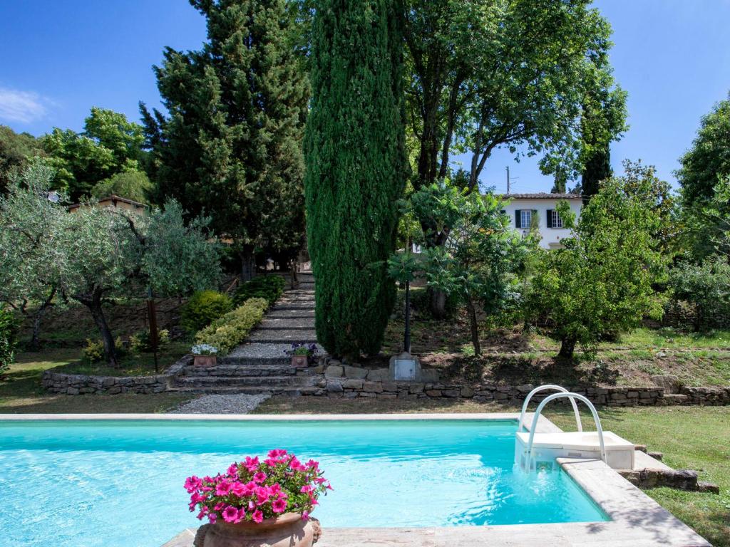 - une piscine dans une cour ornée de fleurs et d'arbres dans l'établissement Villa Arcitenens by Interhome, à Cortone