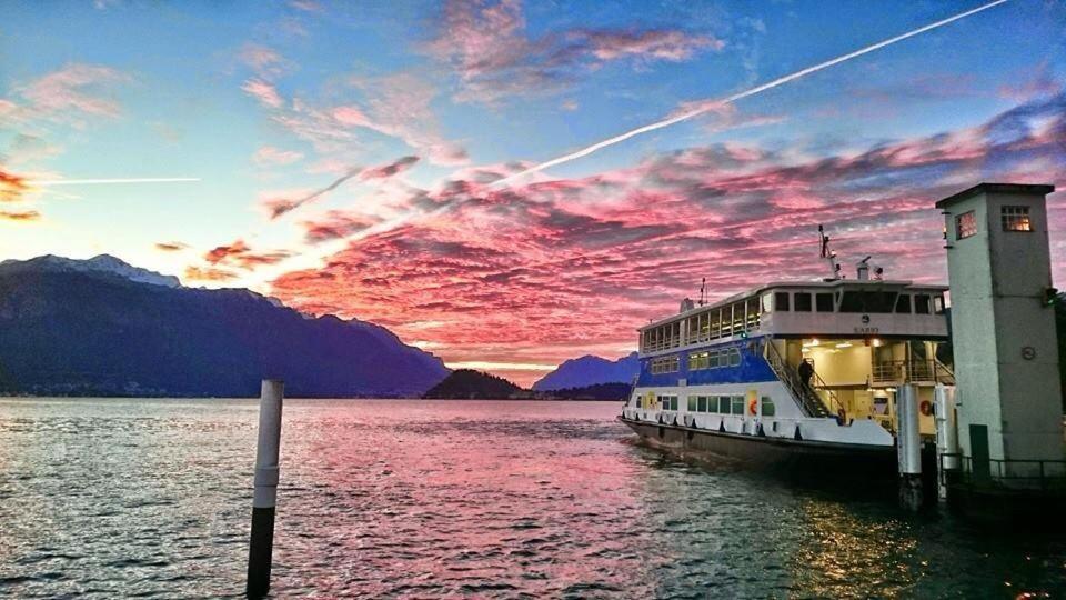 un barco atracado en un muelle con puesta de sol en Hotel Plinio, en Lenno