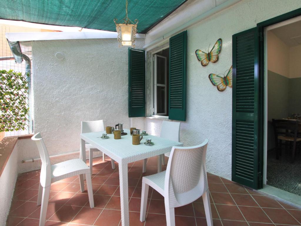einen weißen Tisch und Stühle auf einer Terrasse mit Schmetterlingen an der Wand in der Unterkunft Holiday Home Villa Emma by Interhome in Forte dei Marmi