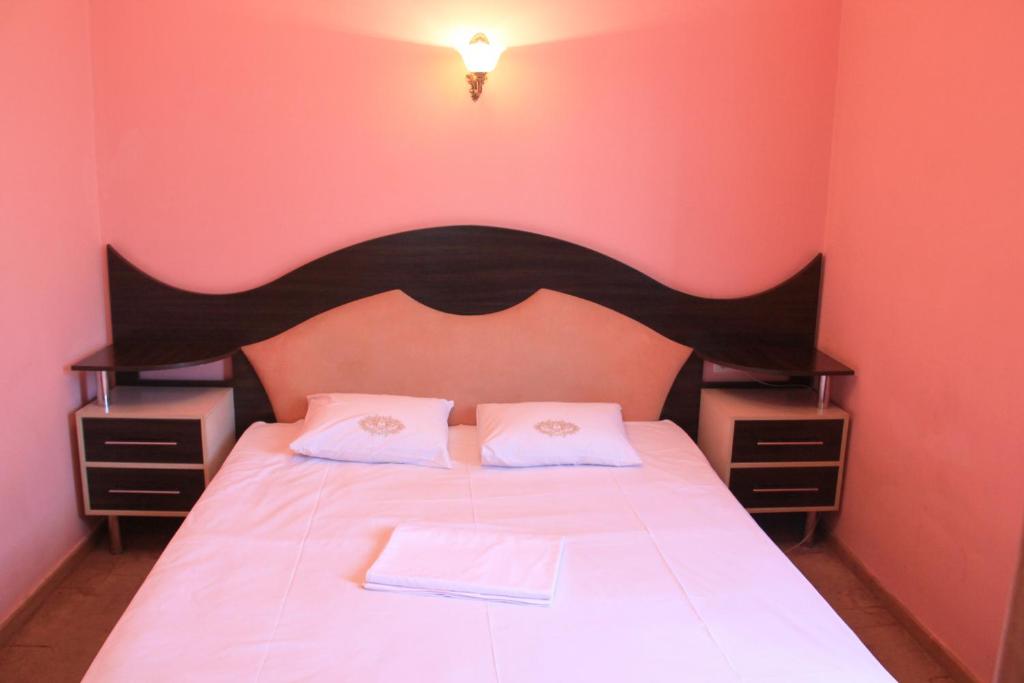Schlafzimmer mit einem Bett mit schwarzem Kopfteil und weißer Bettwäsche in der Unterkunft Argavand Hotel & Restaurant Complex in Argavand