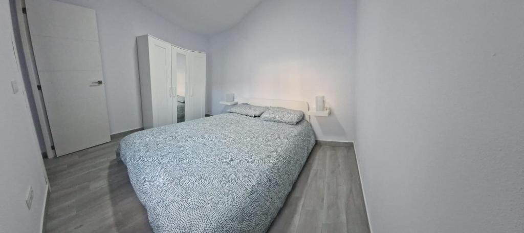 1 dormitorio con 1 cama en una habitación blanca en Apartamento mi currilla, en Sanlúcar de Barrameda