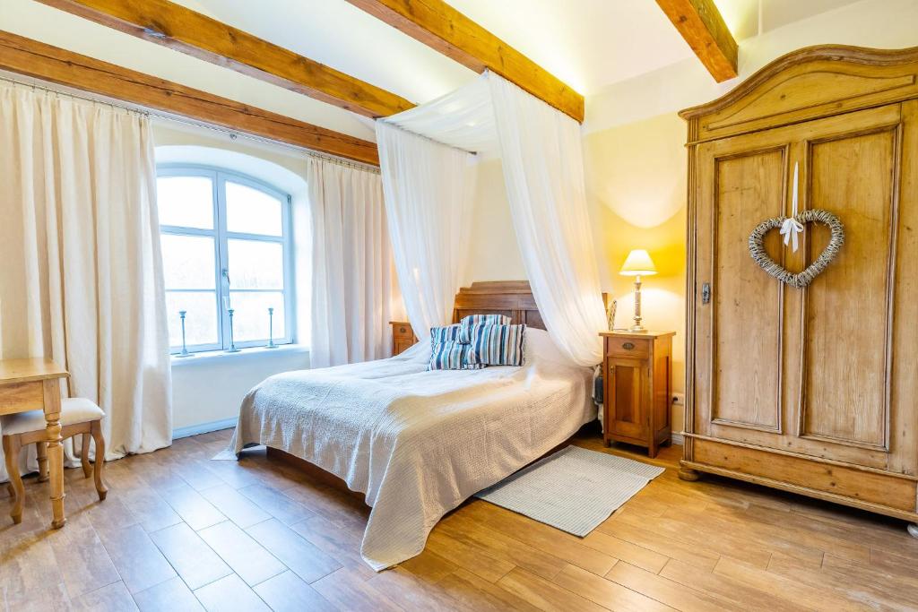 1 dormitorio con 1 cama con un signo cardiaco en la pared en Folwark Karczemka en Małdyty