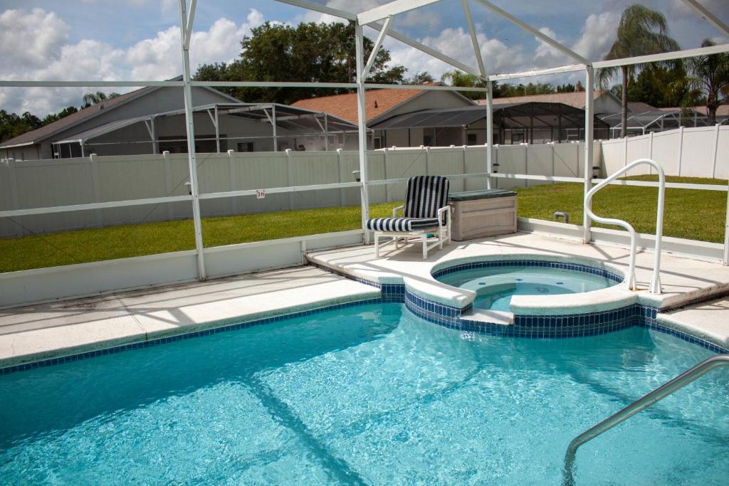 a swimming pool with two chairs sitting next to it at Florida Escape in Orlando