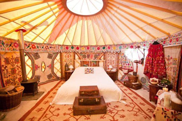 una camera da letto in una tenda con un letto di Festival Yurts Hay-on-Wye a Hay-on-Wye