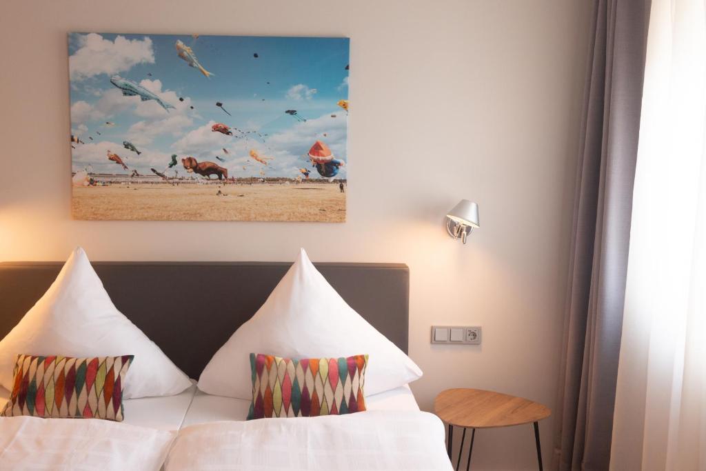 a hotel room with a bed and a painting on the wall at Hotel Herrnbrod & Ständecke in Dreieich