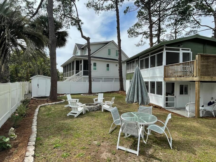 um quintal com uma mesa e cadeiras e uma casa em Renovated Cottage: 4th row from the Beach! em Hilton Head Island