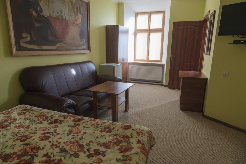Pokój hotelowy z łóżkiem, kanapą i stołem w obiekcie Lemberg Elite Apartments w Lwowie