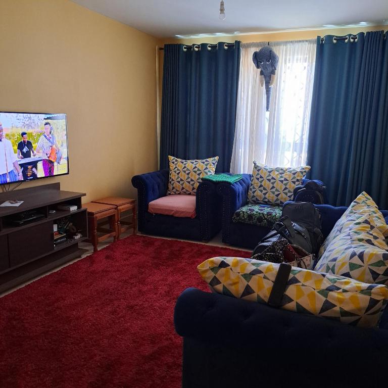 - un salon avec deux canapés et une télévision à écran plat dans l'établissement Shiks Apartment retreat, à Nairobi