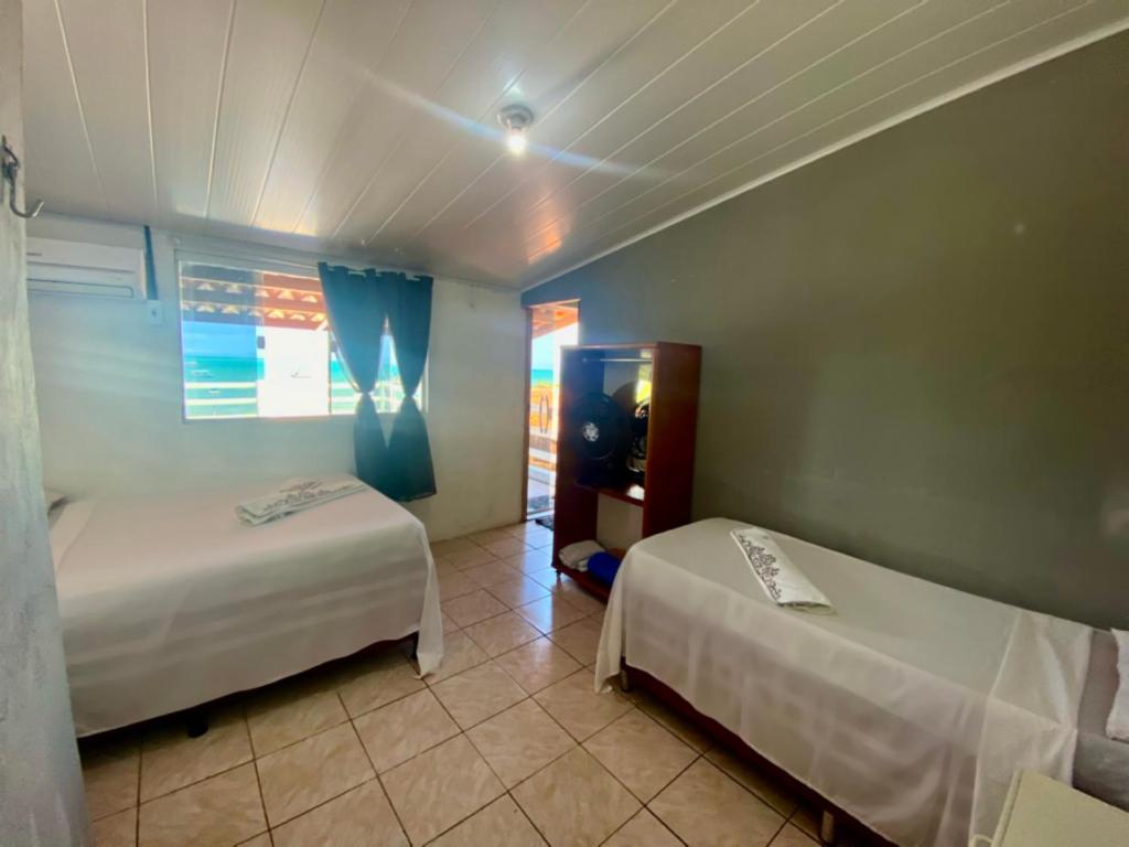 ein Hotelzimmer mit zwei Betten und einem Fenster in der Unterkunft Casa beira mar de Maragogi - Al in Maragogi