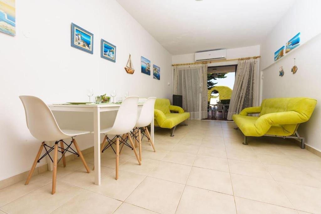 uma sala de estar com uma mesa e cadeiras amarelas em STAY EasyDream Maisonette em Paralimni