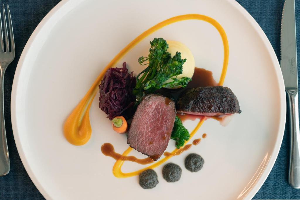 a plate of food with meat and vegetables on it at Thurlestone Hotel in Thurlestone