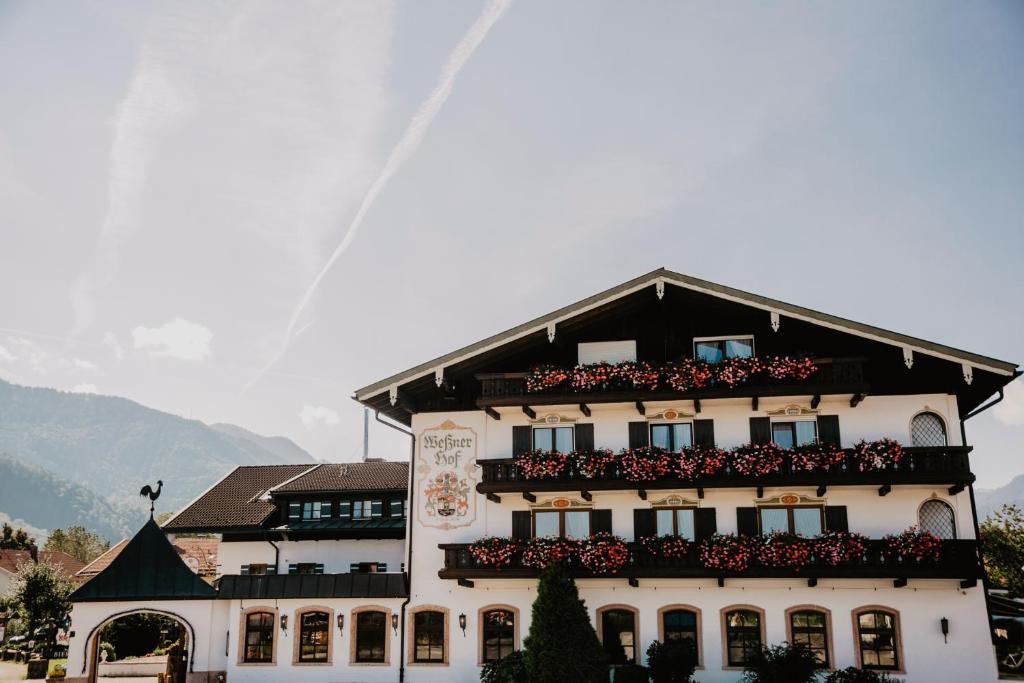 budynek z kwiatami na balkonach w obiekcie Weßner Hof Landhotel & Restaurant w mieście Marquartstein