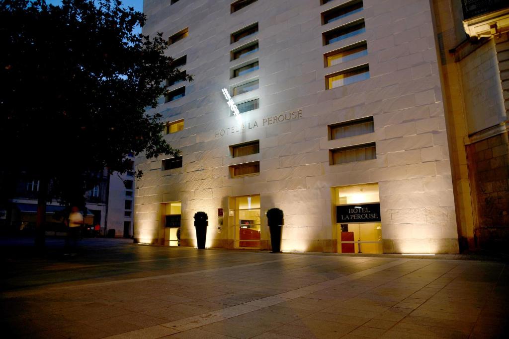 un bâtiment blanc avec un panneau sur son côté dans l'établissement Hôtel La Pérouse, à Nantes