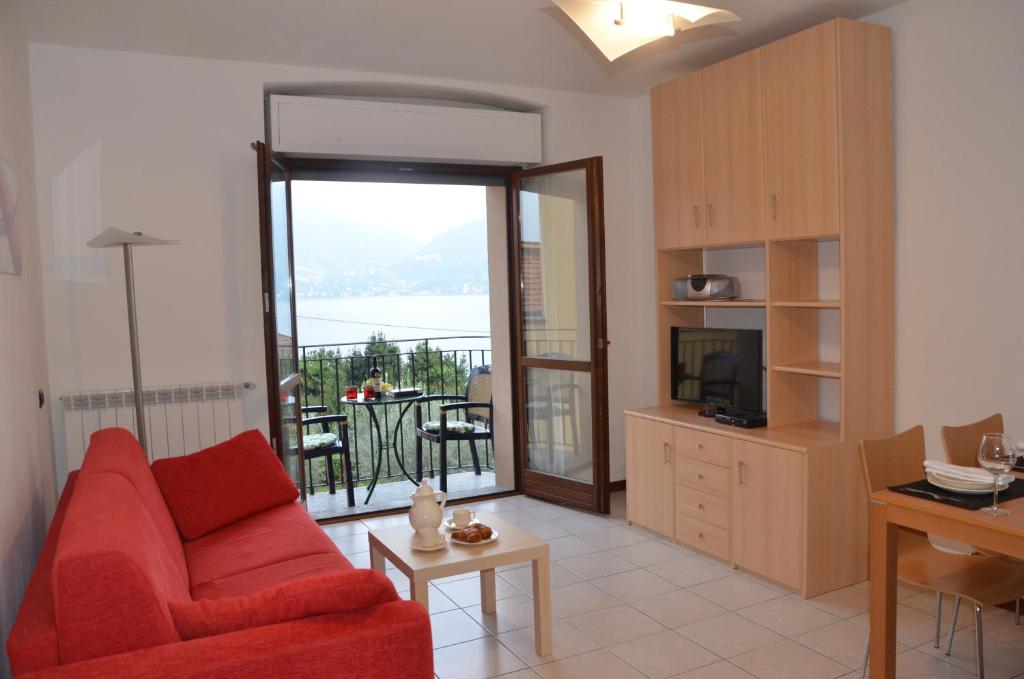 salon z czerwoną kanapą i balkonem w obiekcie Lake Como View Apartement Allegro w mieście Acquaseria