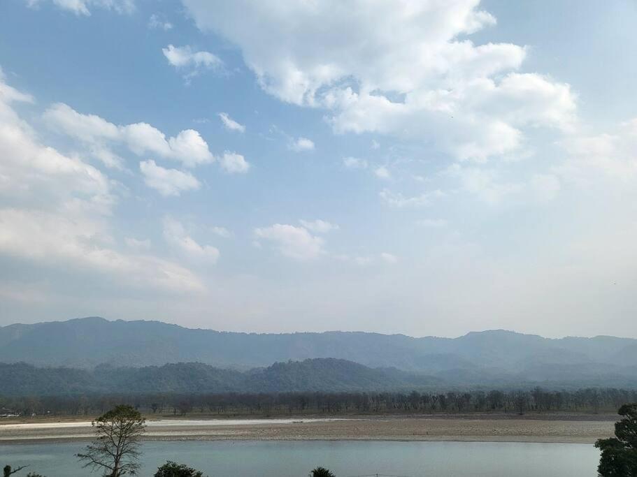 a large body of water with mountains in the background at RASA - The Ganges Rishikesh, Ganga Bhumi Apartment in Rishīkesh