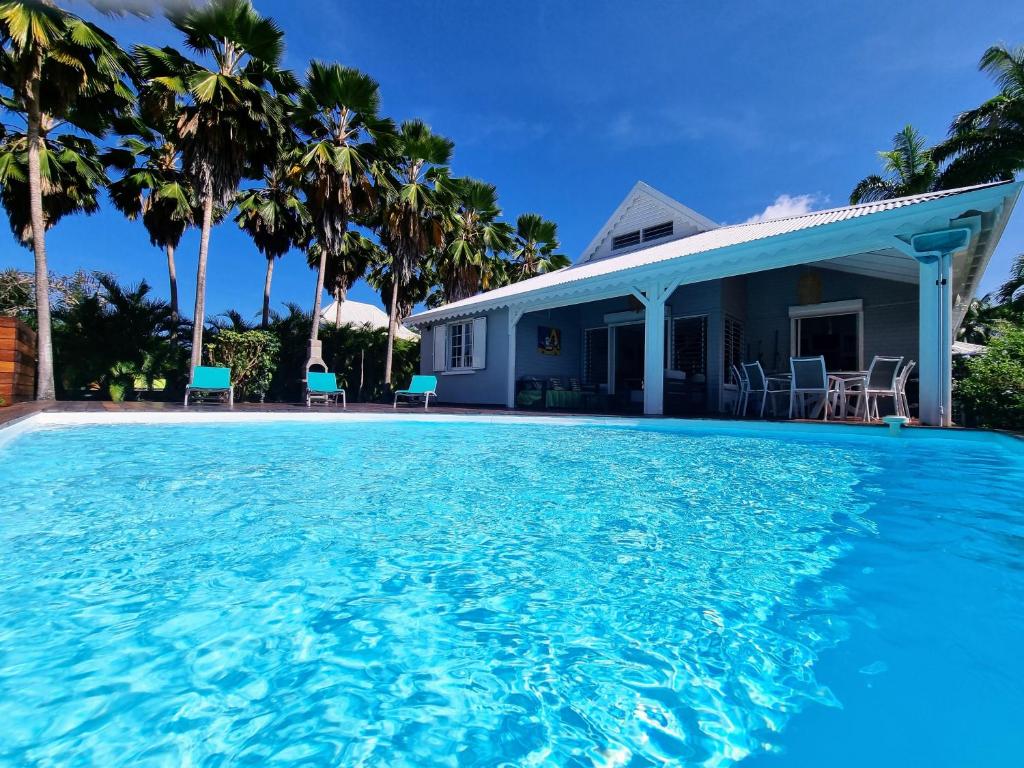 une villa avec piscine devant une maison dans l'établissement Villa Dali, Résidence Aquarelle, Sainte Rose, à Sainte-Rose