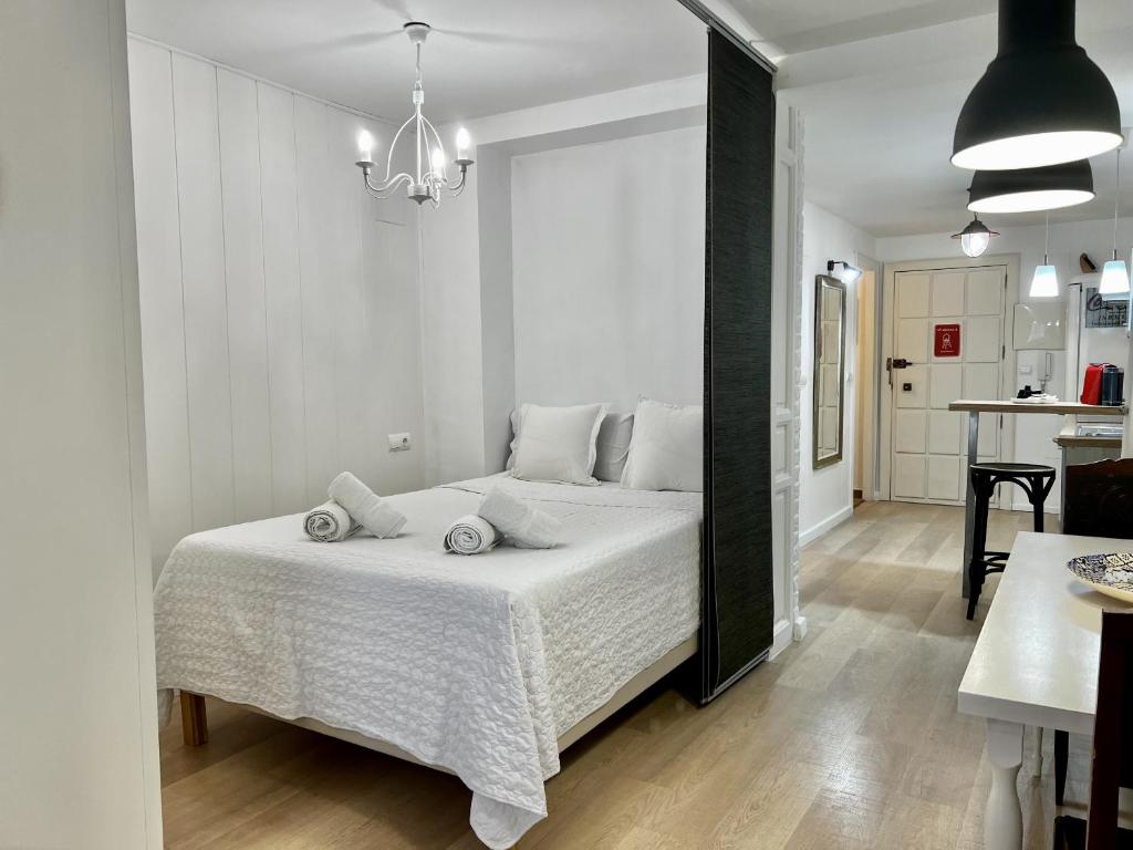 una camera con letto bianco e lampadario pendente di Bright loft city centre by United Renters ad Alicante