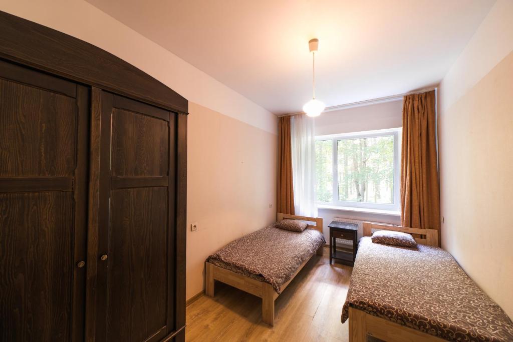 a small room with two beds and a window at Summer hostel Kaija in Jūrmala
