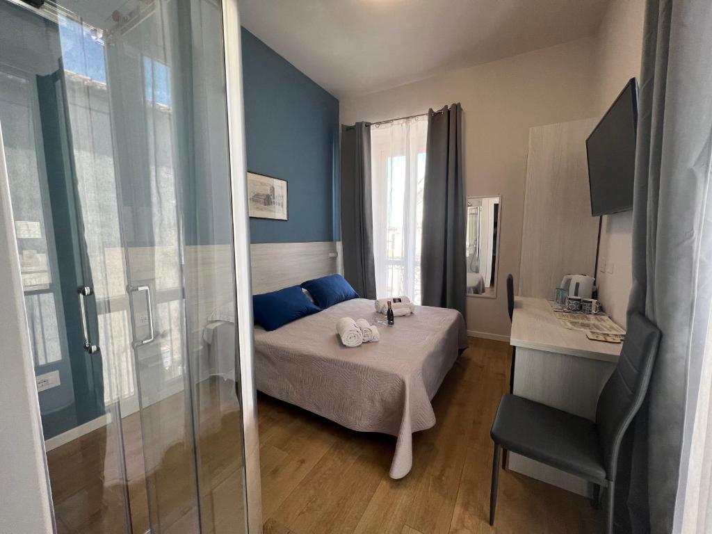 ein Schlafzimmer mit einem Bett mit blauen Kissen und einem Spiegel in der Unterkunft B&B Costa degli Dei in Tropea
