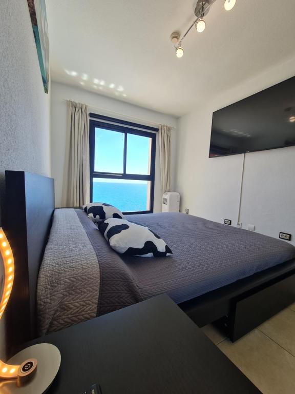 Un dormitorio con una cama grande y una ventana en DELUXE 3 Rooms74m2,TRANSFE-R inc! SEAVIEW on AMADORES,2 heatPOOLs, PARKING, 600 MB,Dishwasher,2Lift,,3 BEACHes, en Playa del Cura