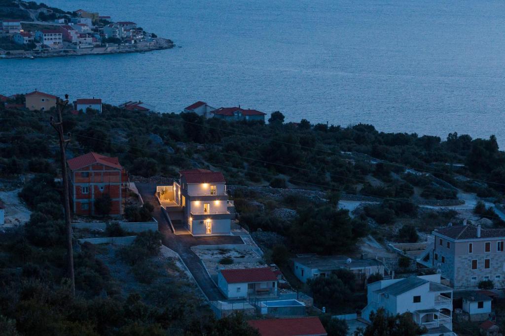 a house on a hill with lights on it at Apartments Sucic in Sevid