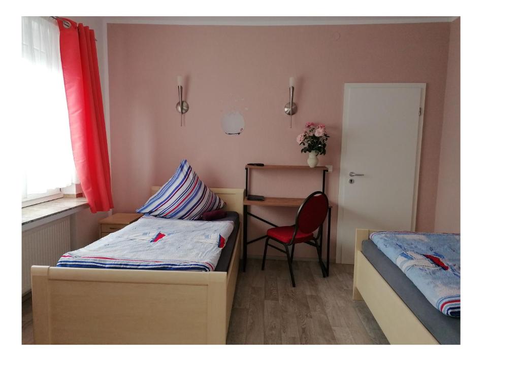 Schlafzimmer mit einem Bett, einem Schreibtisch und einem Stuhl in der Unterkunft Haus Sperbermühle in Hannover