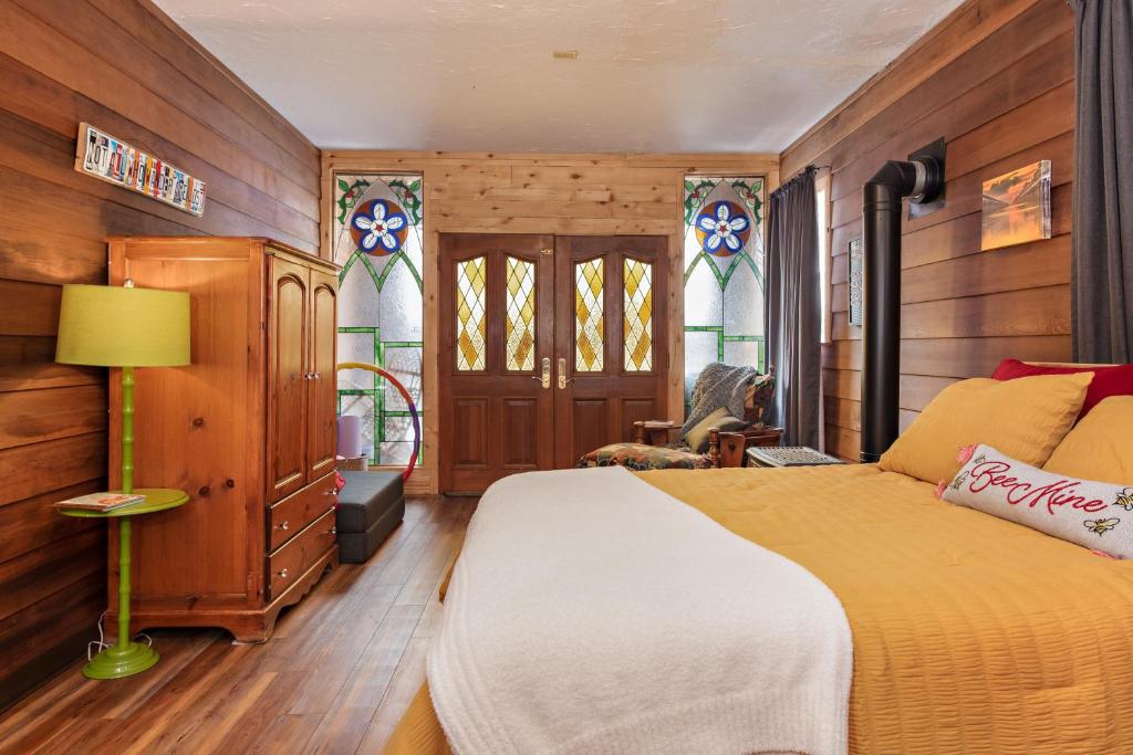 a bedroom with a bed and stained glass windows at Wanderer Studio, AN OFF GRID MOUNTAIN Guest Studio With Fantastic Views in Glenwood Springs