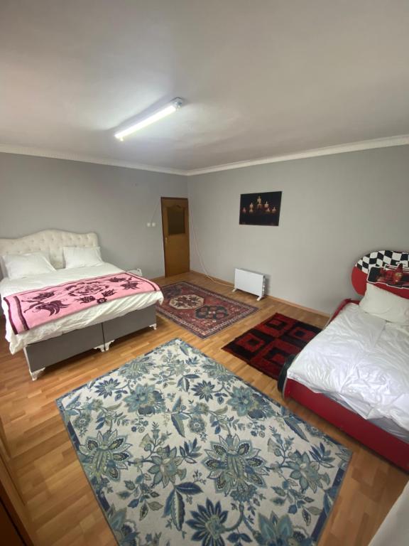 a bedroom with two beds and a rug at Triplex house near the airport in Arnavutköy