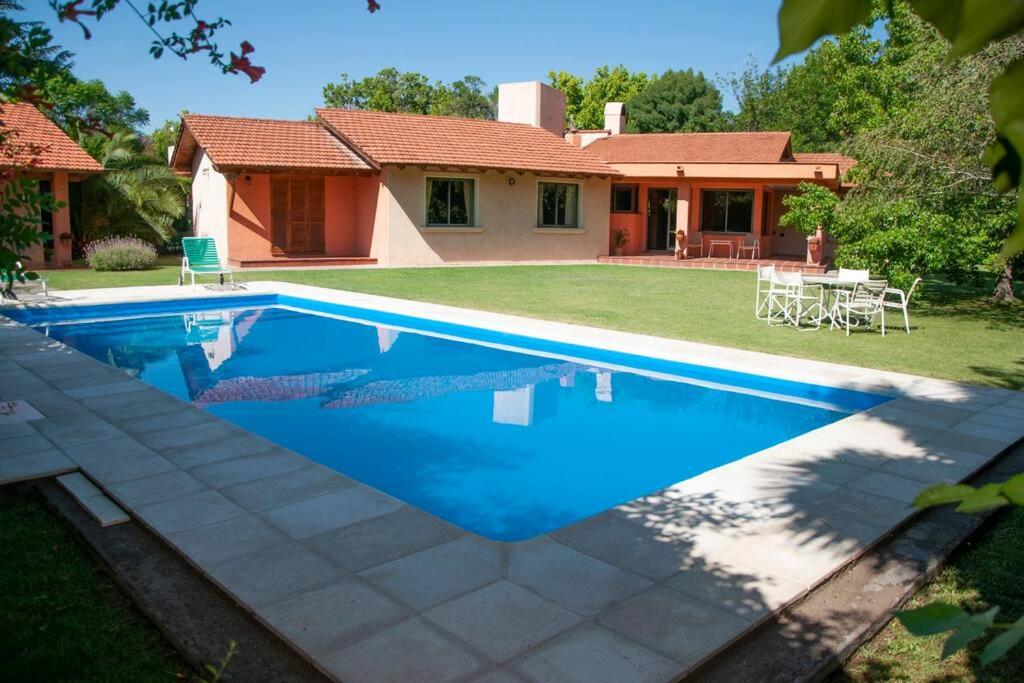 a swimming pool in front of a house at Casa luminosa con pileta ¡ideal para descansar! in Ciudad Lujan de Cuyo