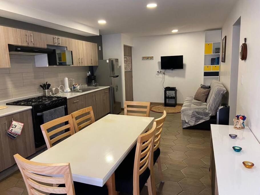 a kitchen and living room with a table and chairs at CENTRAL APARTMENT IN THE HEART OF MEXICO CITY in Mexico City