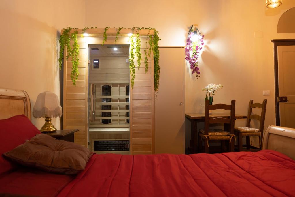 1 dormitorio con cama roja y comedor con mesa en I' Quercecchio-Relax tra le torri en San Gimignano