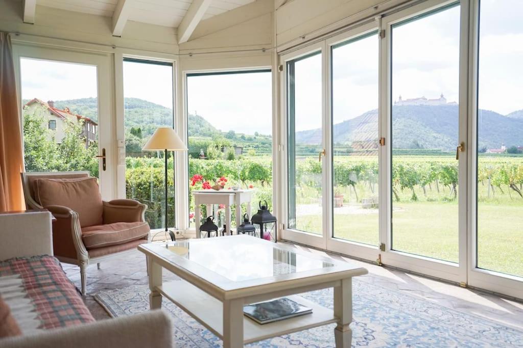 sala de estar con mesa de centro y ventanas grandes en Wonderful Villa among the Vineyards, en Palt