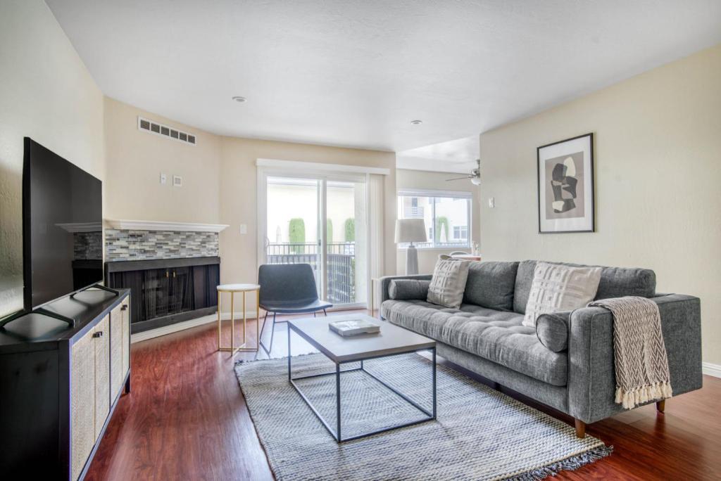 a living room with a couch and a tv at Redwood City 2BR w Pool WD Parking nr WF TJ SFO-627 in Redwood City