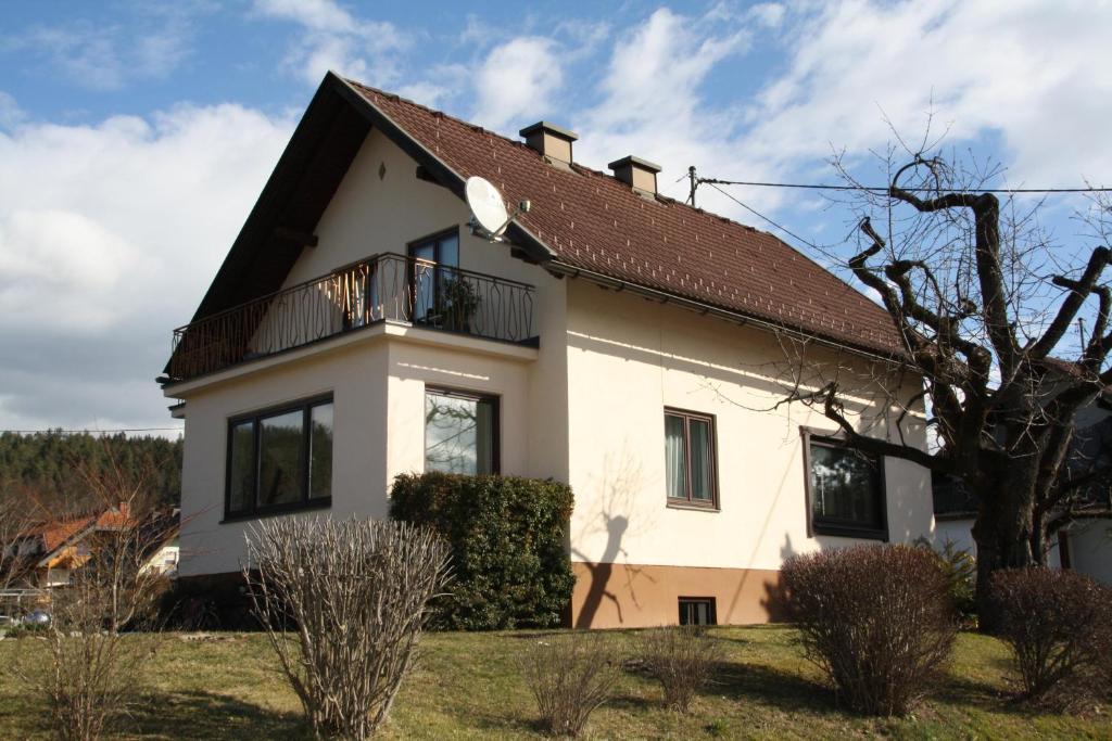 uma casa branca com um telhado castanho em Haus Sonnental Velden am Wörthersee em Velden am Wörthersee