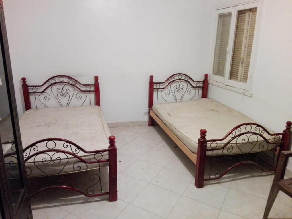 - deux lits assis l'un à côté de l'autre dans une pièce dans l'établissement 13 خلف عمارات العبور مصر الجديده, au Caire
