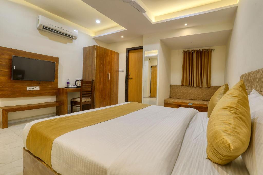 a hotel room with a bed and a television at Hotel Konark - Vijay Nagar in Indore