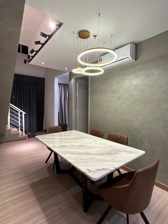 a dining room with a white table and chairs at Melaka Duplex Penthouse 3 Bedroom The Wave Residence 9pax in Melaka