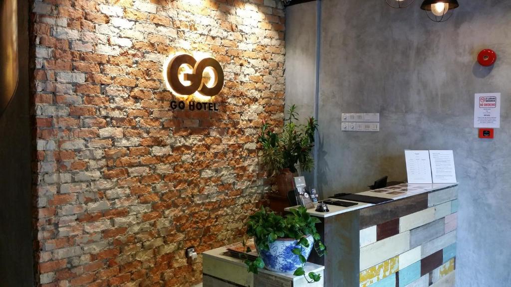 een stenen muur met een bord dat zegt ga naar binnen bij Go Hotel in Subang Jaya